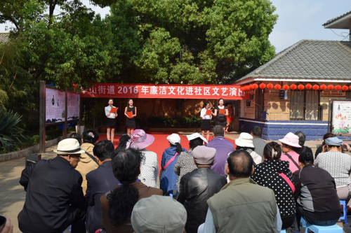 图片说明：志愿者在在为群众朗诵廉政诗歌《廉洁颂》