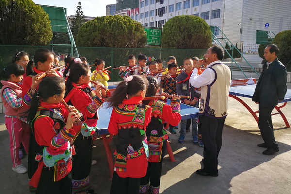 课间时间，热爱艺术的彝族撒尼学生认真地跟老师学习演奏技巧。.jpg