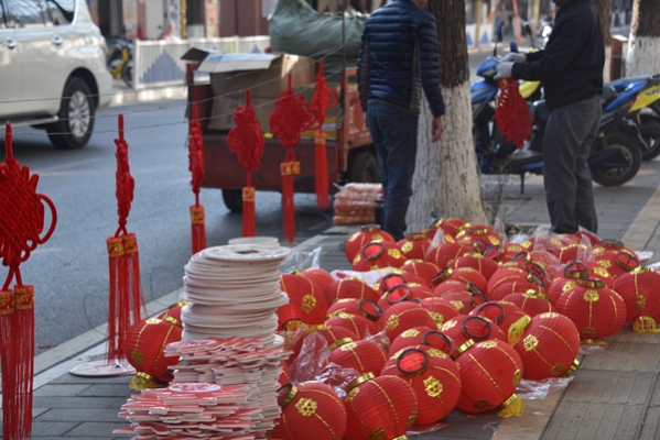 街头小摊上堆满了红灯笼、中国结，等着人们带回家，换新符。.jpg