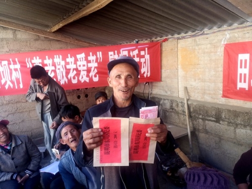 老人举着收到的慰问金，开怀而笑，张晶媛_副本.jpg