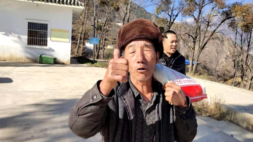 扛着送来的大米，大爷竖起了大拇指，喜_副本.jpg